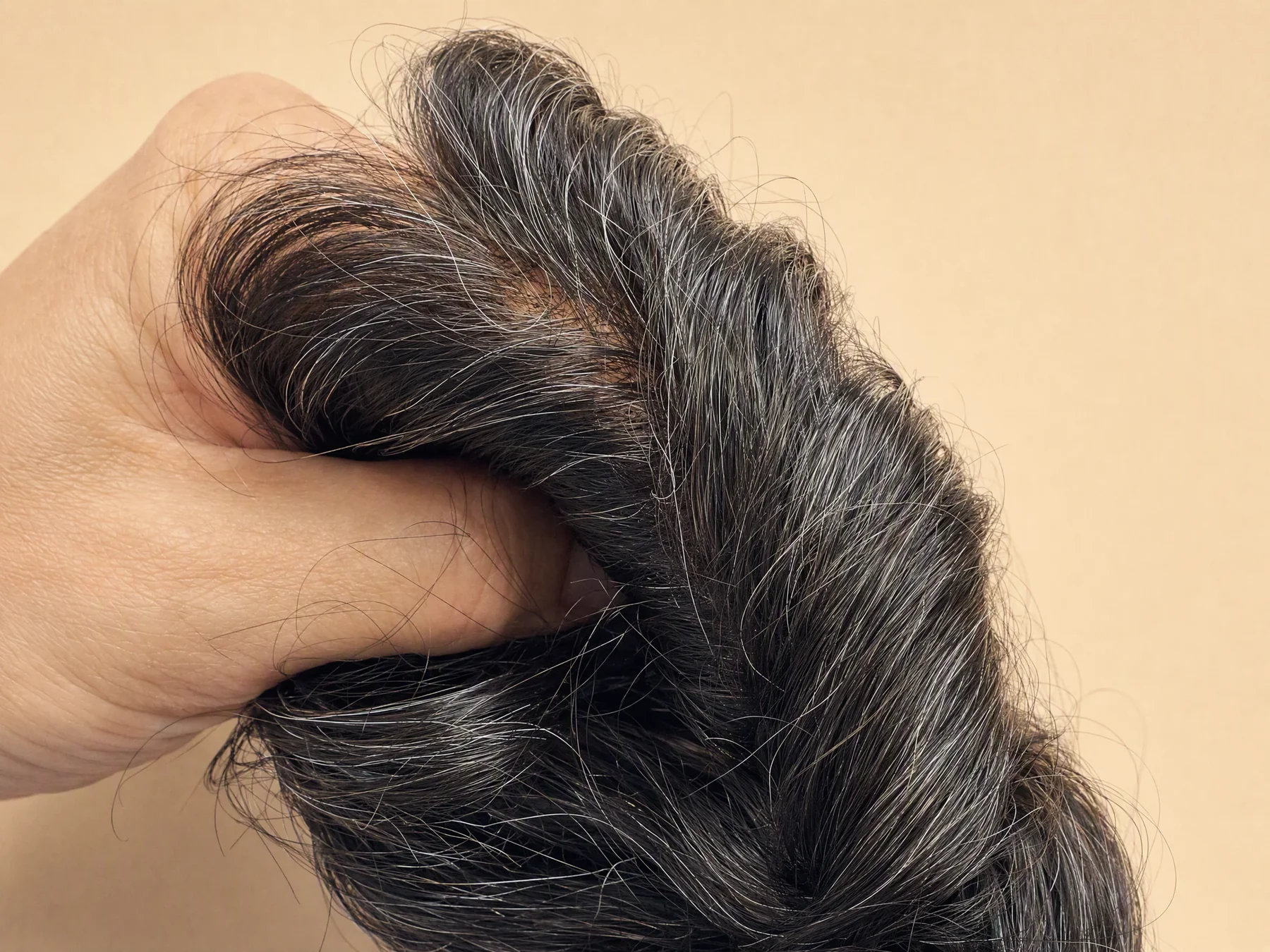 Primer plano de la raya, la implantación y las canas.
